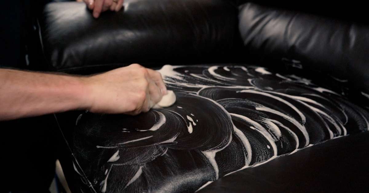 Person using a sponge to clean leather